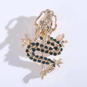 Detailed macro shot of a golden dragon brooch featuring sparkling green rhinestones
