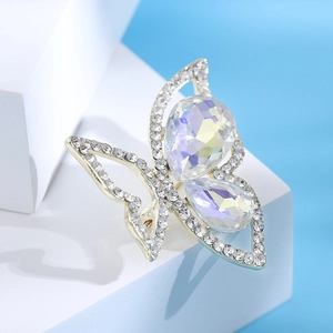 Close-up of golden butterfly brooch with pear-cut iridescent gems and sparkling rhinestones