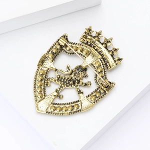 Macro detail of retro crown lion shield brooch with antique gold plating and relief