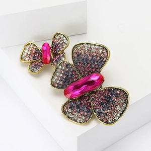Vintage gold butterfly brooches set with pink and purple rhinestones on white blocks