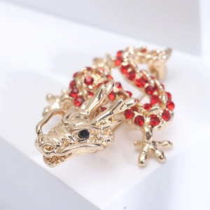 Macro view of golden Chinese dragon brooch featuring sparkling red rhinestones and details