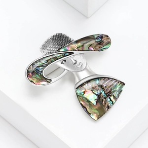 Elegant silver brooch featuring an artistic lady in a sun hat with abalone shell inlays