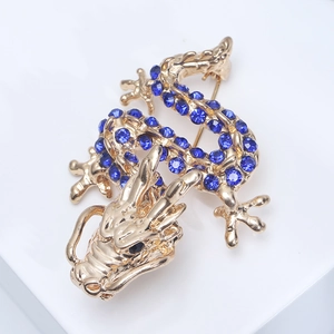 Detailed macro view of a golden dragon brooch with shimmering blue rhinestones and gems