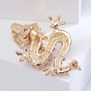 Detailed back view of a golden dragon brooch featuring a secure pin clasp and rhinestones