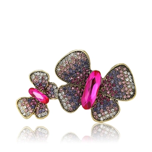 Vintage gold alloy double butterfly brooch with pink and purple rhinestones on white background
