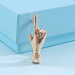Detailed macro view of rose gold finger gesture pendant with sparkling cubic zirconia stone
