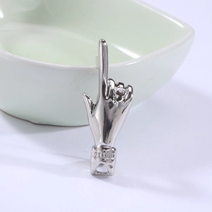Detailed view of silver hand gesture brooch with embedded zircon and embossed cuff detail