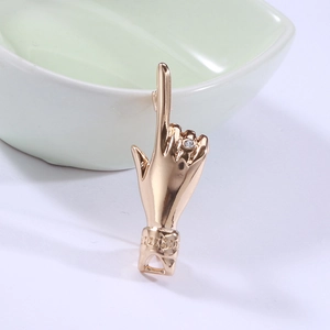 Macro shot of a gold hand-shaped gesture brooch with sparkling diamond inlay details