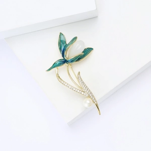Broche magnolia élégante dorée avec émail bleu-vert, zircons et perle blanche ronde
