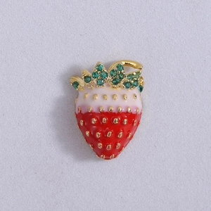 Detail of strawberry brooch with red gradient enamel and green zircon leaves in gold frame