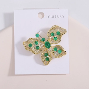 Vue détaillée de la broche papillon en or sertie de zircons et de pierres vert émeraude