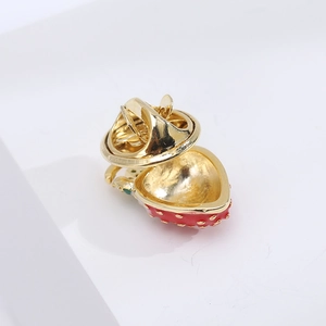 Macro view of the gold-plated butterfly clutch backing on a red enamel strawberry pin
