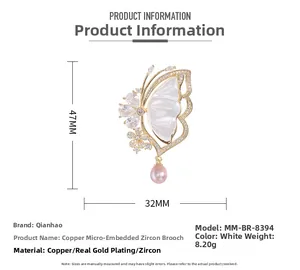 Detail of luxury butterfly brooch with shell petals, zircon stones, and a purple pearl drop