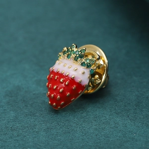Exquisite strawberry brooch with red enamel and green zircon stones on a gold alloy base