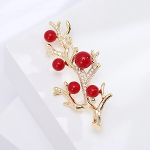 Broche élégante branche dorée avec cinq perles rouges et pavé de zircons étincelants