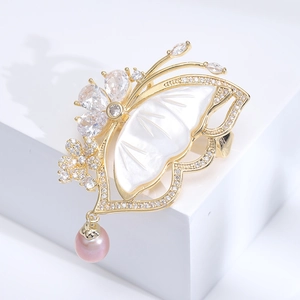 Detail of butterfly brooch with shell wing, cubic zirconia flowers and a pink pearl drop