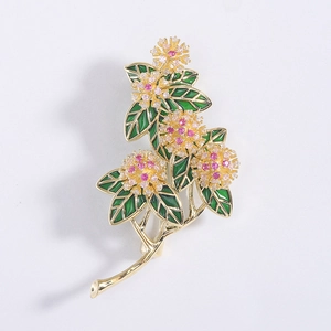 Detailed close-up of zircon flower brooch with gold plating and green enamel leaves