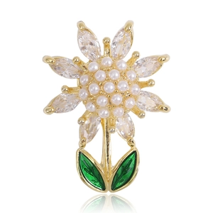Détail de la broche tournesol avec pétales en cristal, cœur en perles et feuilles