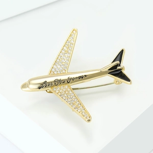 Detail showing gold aircraft brooch with zircon inlay and Love You Forever engraving