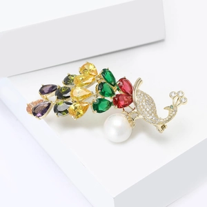 Elegant gold peacock brooch with multicolored crystals and a large white pearl accent