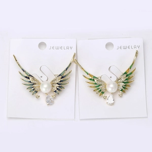 Detailed view of enamel angel wing brooch with natural pearl and hanging zircon stone