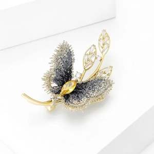 Élégante broche papillon en or avec ailes en tissu texturé et pierre précieuse jaune