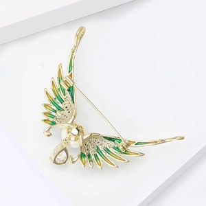 Detail of luxury angel wing brooch with enamel gradient, pearl and zircon drop