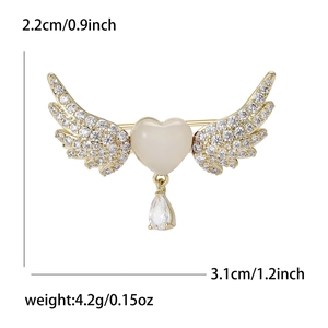 Close-up of angel wings heart brooch with opal-like stone and pear-shaped drop pendant