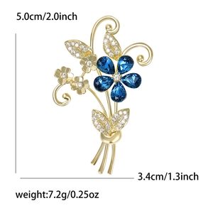 Élégante broche bouquet doré avec cristaux bleus en goutte et micro-zircons étincelants