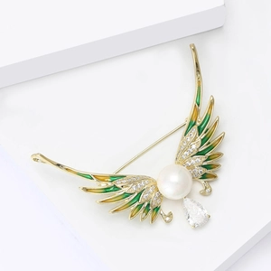 Detail of angel wing brooch with green enamel, white pearl and zircon drop