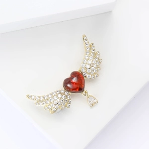 Elegant gold-tone heart wings brooch with ruby red zircon and sparkling cubic zirconia stones