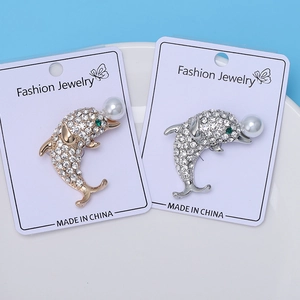 Détails des broches dauphin avec strass blancs et perles blanches en finitions or et argent