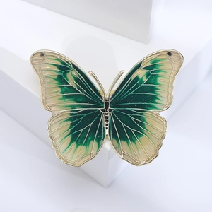 Detailed macro view of enamel butterfly brooch with green gradient and metallic veins