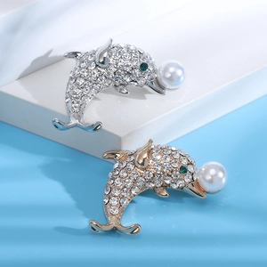 Détails des broches dauphin avec cristaux étincelants et perles sur présentoir