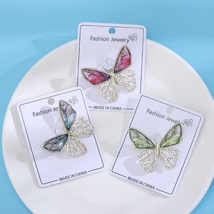 Detailed close-up of hollow butterfly brooches with enamel gradient and sparkling crystals