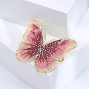Macro shot of butterfly brooch with purple enamel wings and gold metallic edges