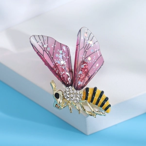 Détail d'une broche abeille avec plaquage or, pavé de cristaux et ailes en émail