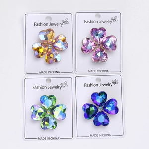 Detail of four-leaf clover brooches with heart-cut crystals in four vibrant colors