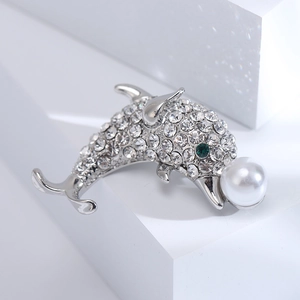 Vue détaillée de la broche dauphin avec strass scintillants et une grande perle blanche