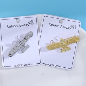 Close-up of eagle brooches in gold and silver finish on white display cards