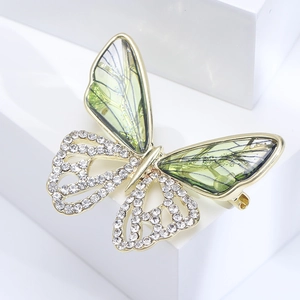 Elegant butterfly brooch with green wings and white rhinestones on gold base