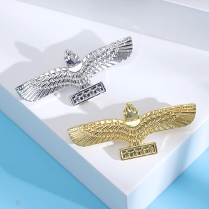 Minimalist eagle totem brooches in gold and silver finish on white geometric display