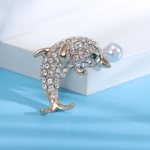 Vue détaillée de la broche dauphin avec des strass étincelants et une perle blanche