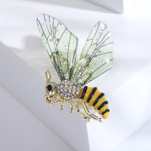 Détail macro d'une broche abeille avec ailes scintillantes et sertissage de strass