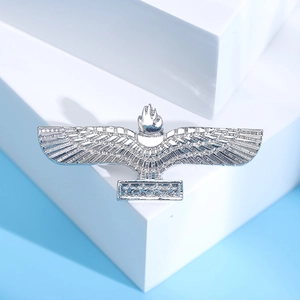 Detail of silver alloy eagle brooch with star accents on a clean light blue background