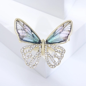 Macro detail of butterfly brooch with blue gradient wings and crystal rhinestones