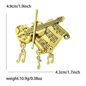 Golden violin and musical note brooch pin with detailed engravings on a white background
