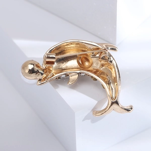 Vue arrière détaillée d'une broche dauphin dorée montrant le fermoir de sécurité rotatif sûr