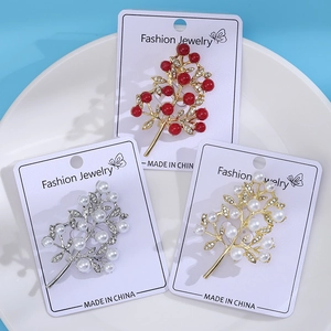 Three elegant pearl and rhinestone tree brooches in gold and silver finishes on cards