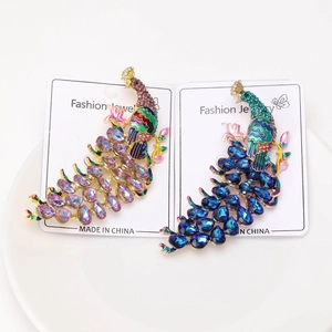 Detail view of crystal peacock brooches with enamel finish on fashion jewelry card